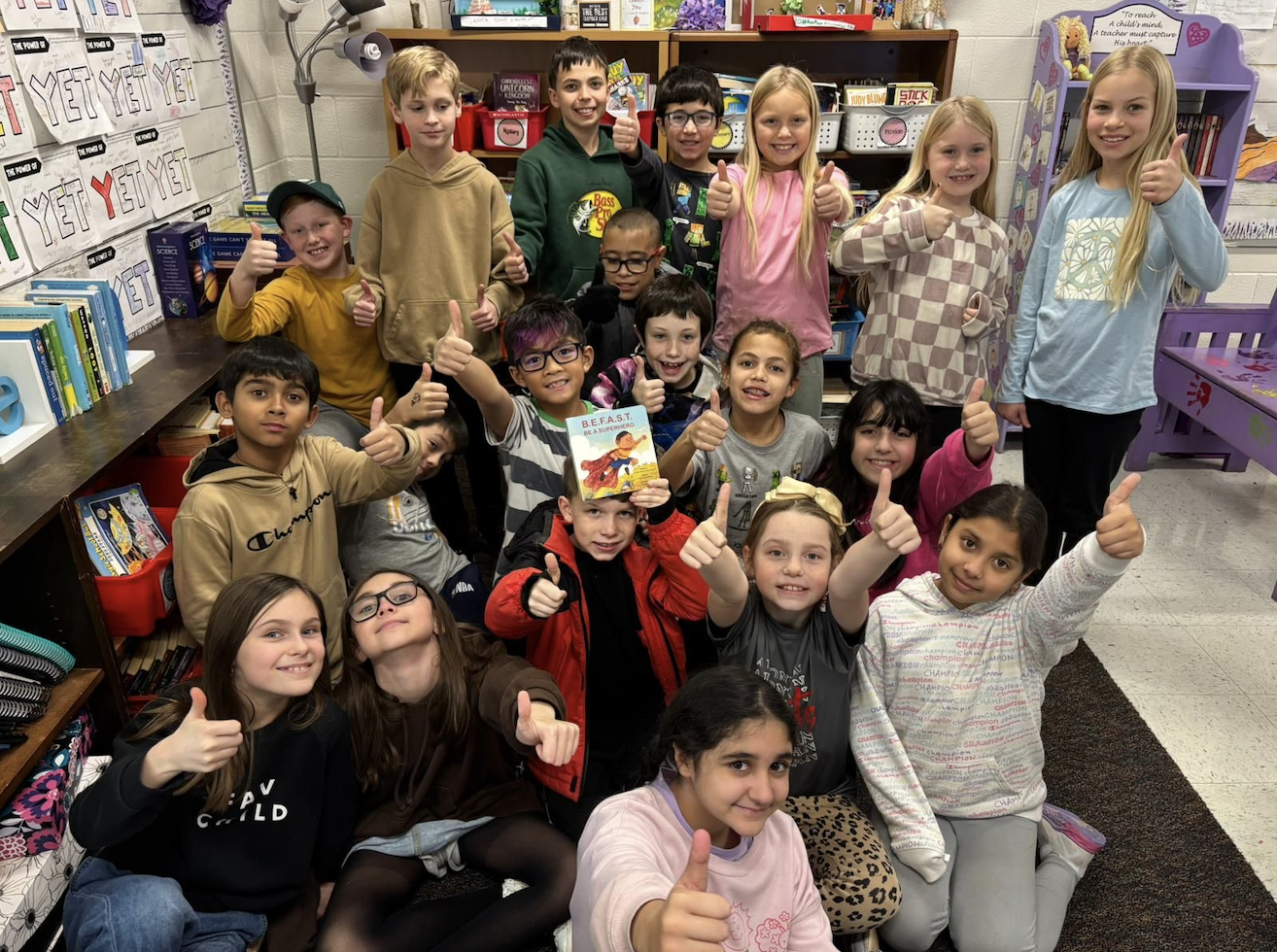 Students giving thumbs up with the BEFAST book